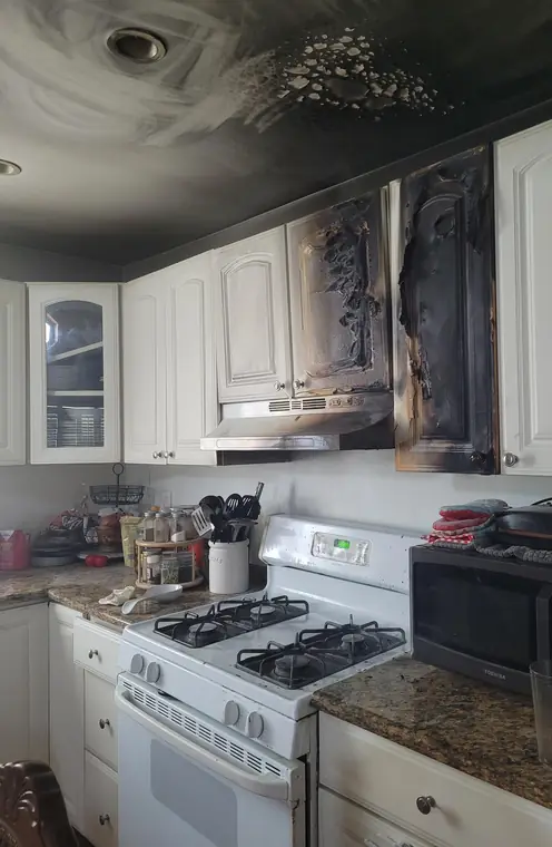 Kitchen fire: melted cabinet doors and soot across the ceiling