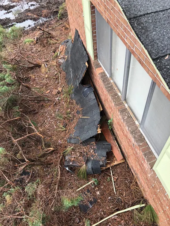 Roof debris thrown against the house