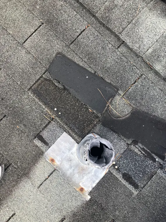 Crushed roof vent and torn shingles