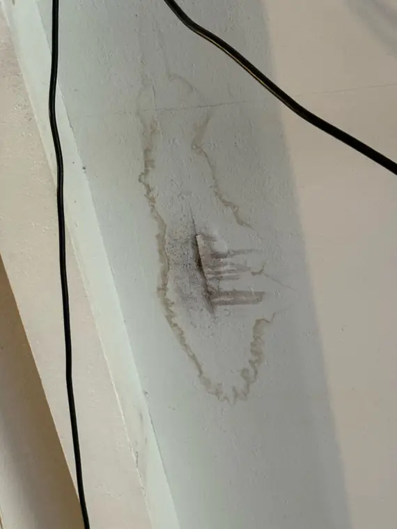 Water stain spreading across a ceiling beam